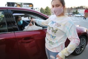 Handing Omaha Hunger Experience meal to a participant in her car.