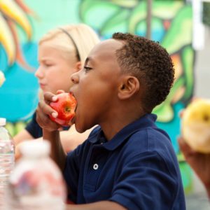 child eating apple at lunch